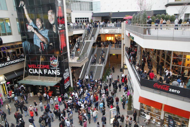 A crowd of people walking around an indoor mall.